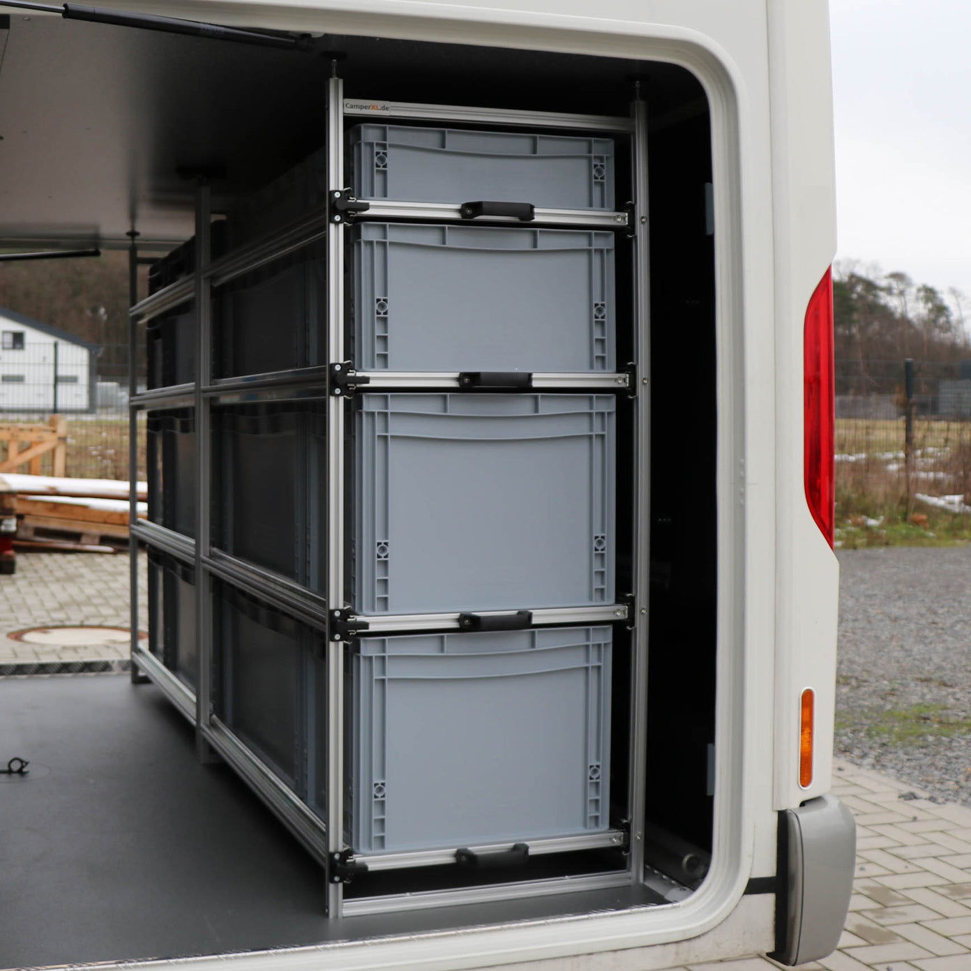 Gefüllte Euroboxen in voll ausziehbaren Heckgarage-Regalen im Wohnmobil Carthago Chic C-Line.